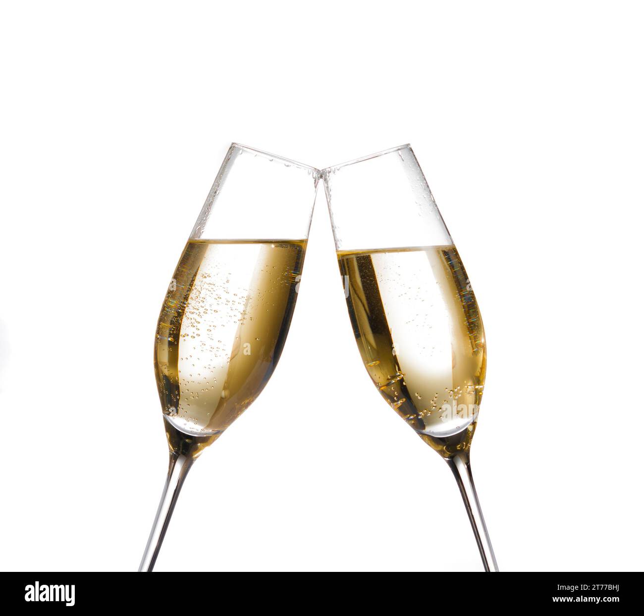 two champagne flutes with golden bubbles make cheers on white