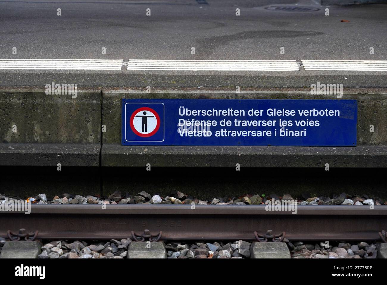 Banner with a pictogram saying it is forbidden to cross the tracks at the railway station in Urdorf, Switzerland. Stock Photo