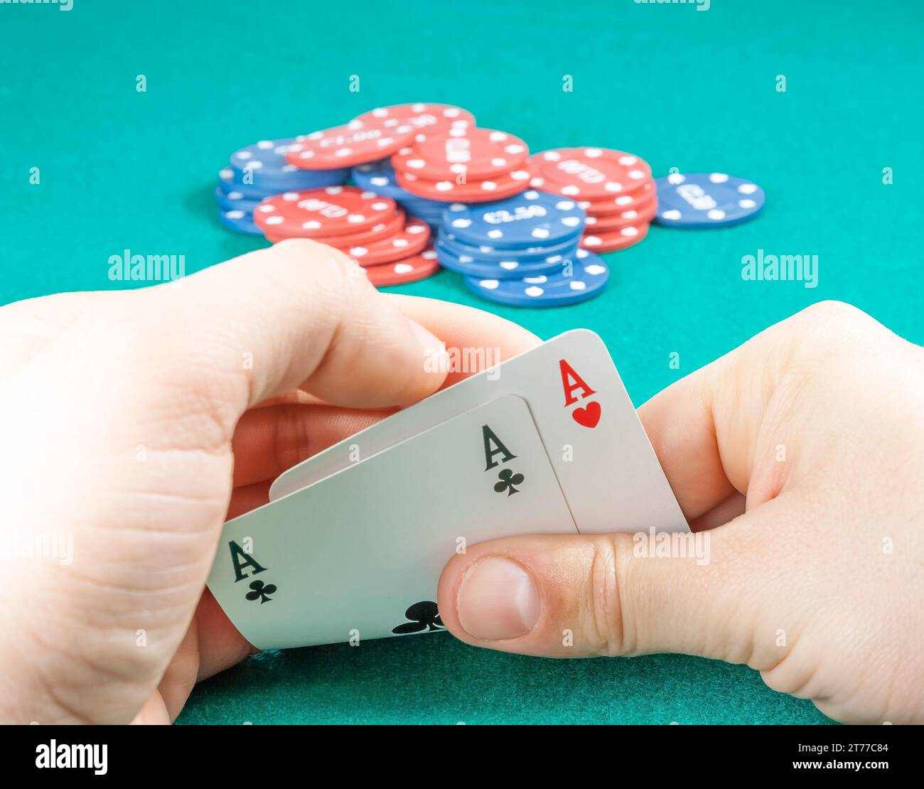 winning playing cards in a man hands near fiches on gaming table Stock Photo