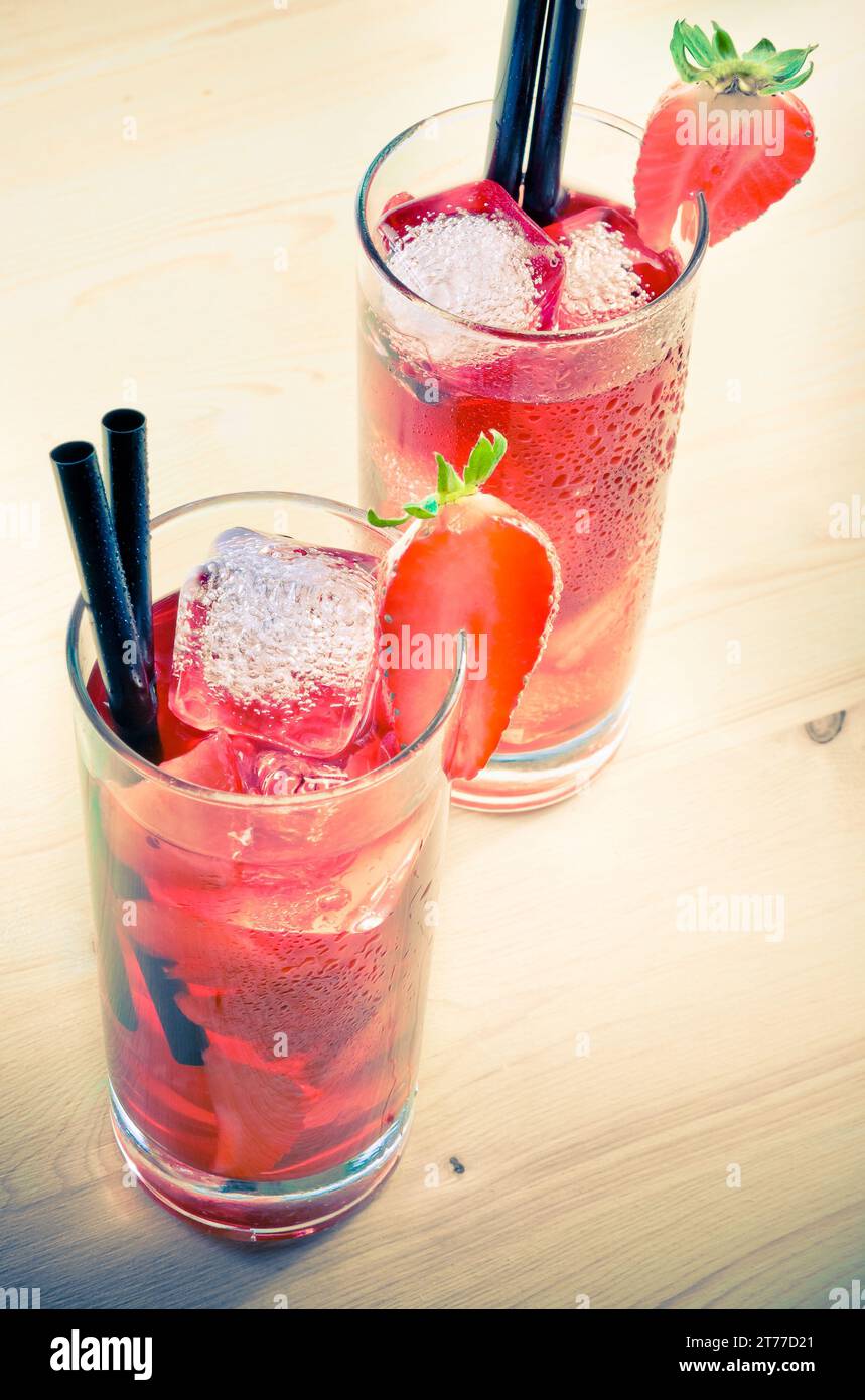 glasses of strawberry cocktail with ice on old wood table, old style atmosphere Stock Photo