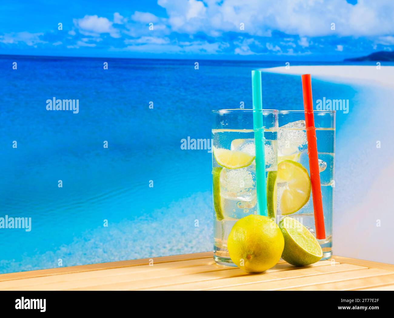 glasses of cocktail with lime slice on blur beach,sky background on wood table Stock Photo