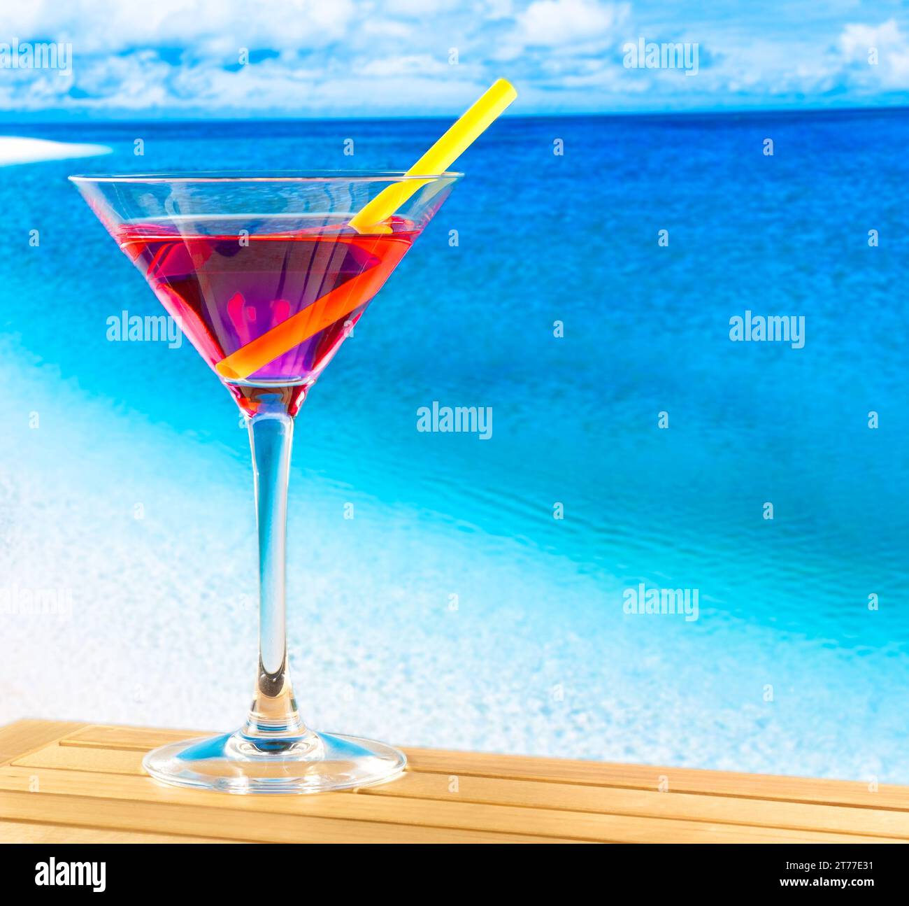red cocktail on wood table with blur beach background and space for text Stock Photo