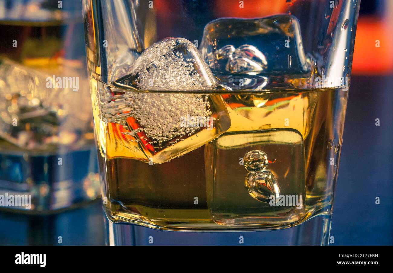 detail of whiskey with ice on bar table lounge bar atmosphere Stock Photo