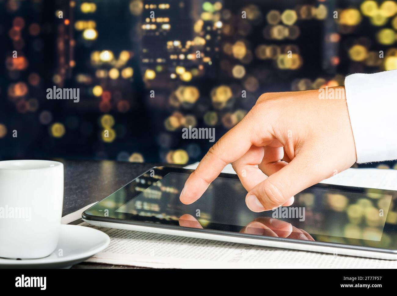 business man touch digital tablet on business newspaper with blur city in background Stock Photo