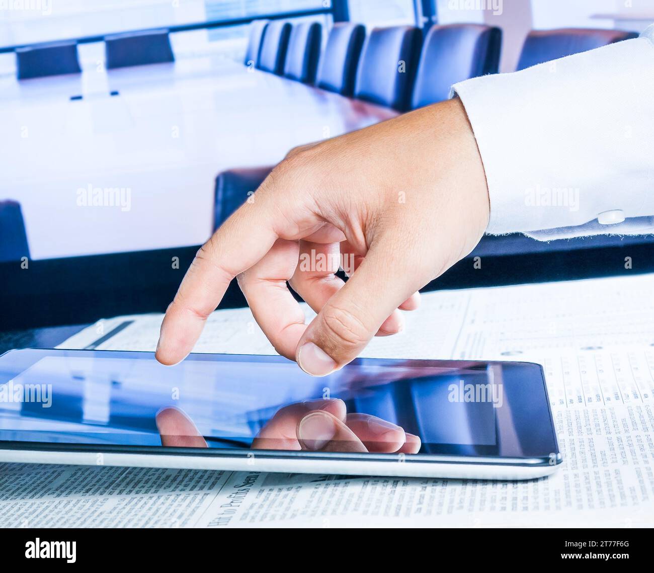business man touch digital tablet on business newspaper in the office Stock Photo