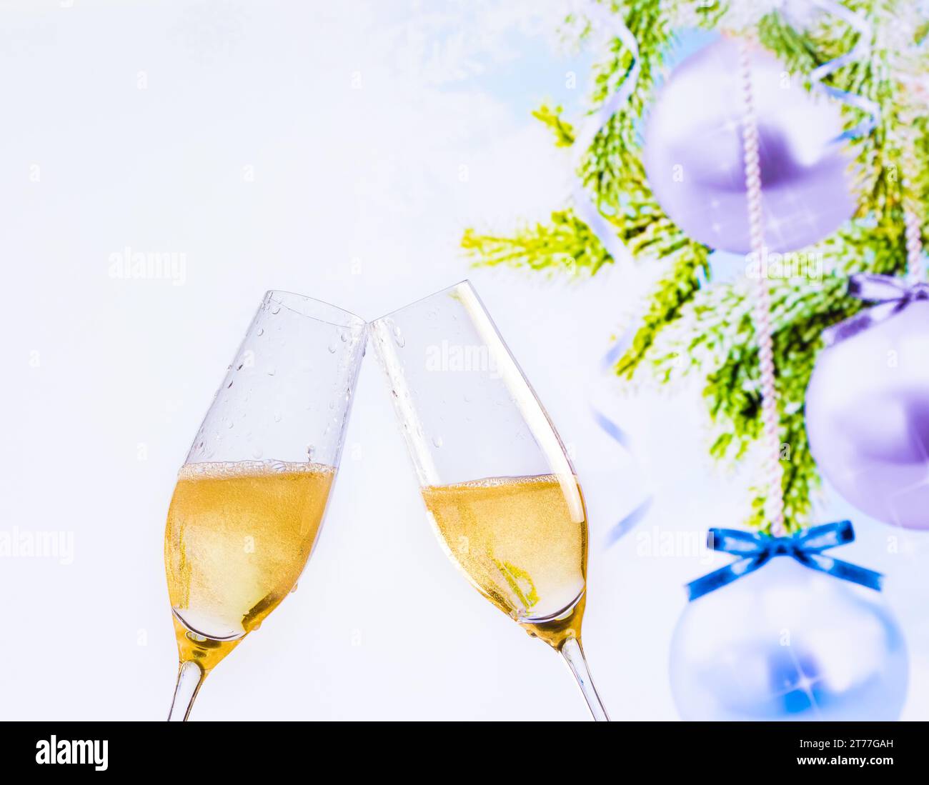 champagne flutes with golden bubbles make cheers on christmas tree decoration background, christmas atmosphere Stock Photo