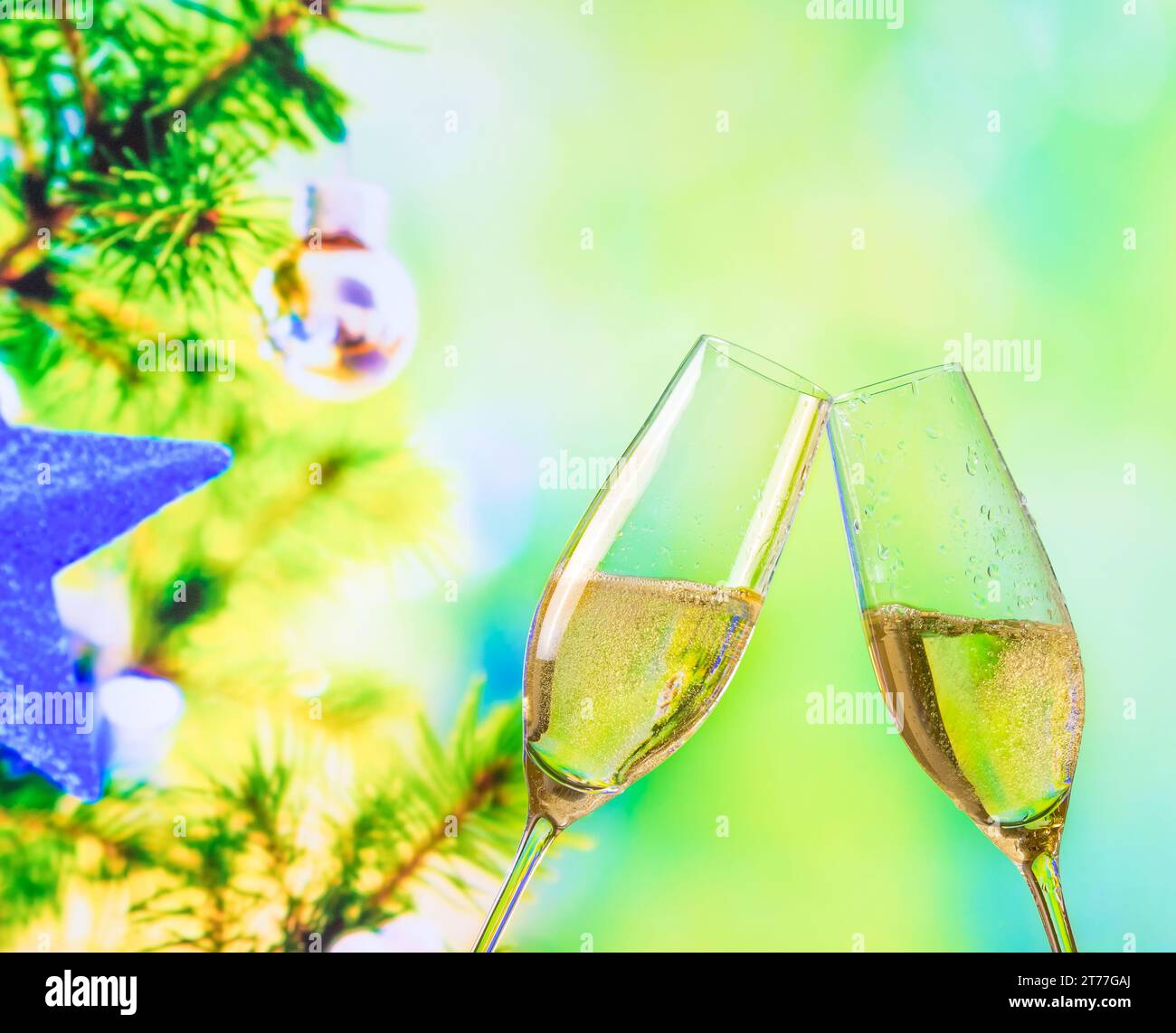 champagne flutes with golden bubbles make cheers on christmas tree decoration background, christmas atmosphere Stock Photo