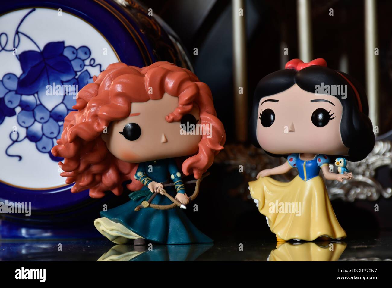 Funko Pop action figures of Disney princesses Merida (Brave) and Snow White. Medieval castle, fabulous kingdom, porcelain blue keg with pattern. Stock Photo