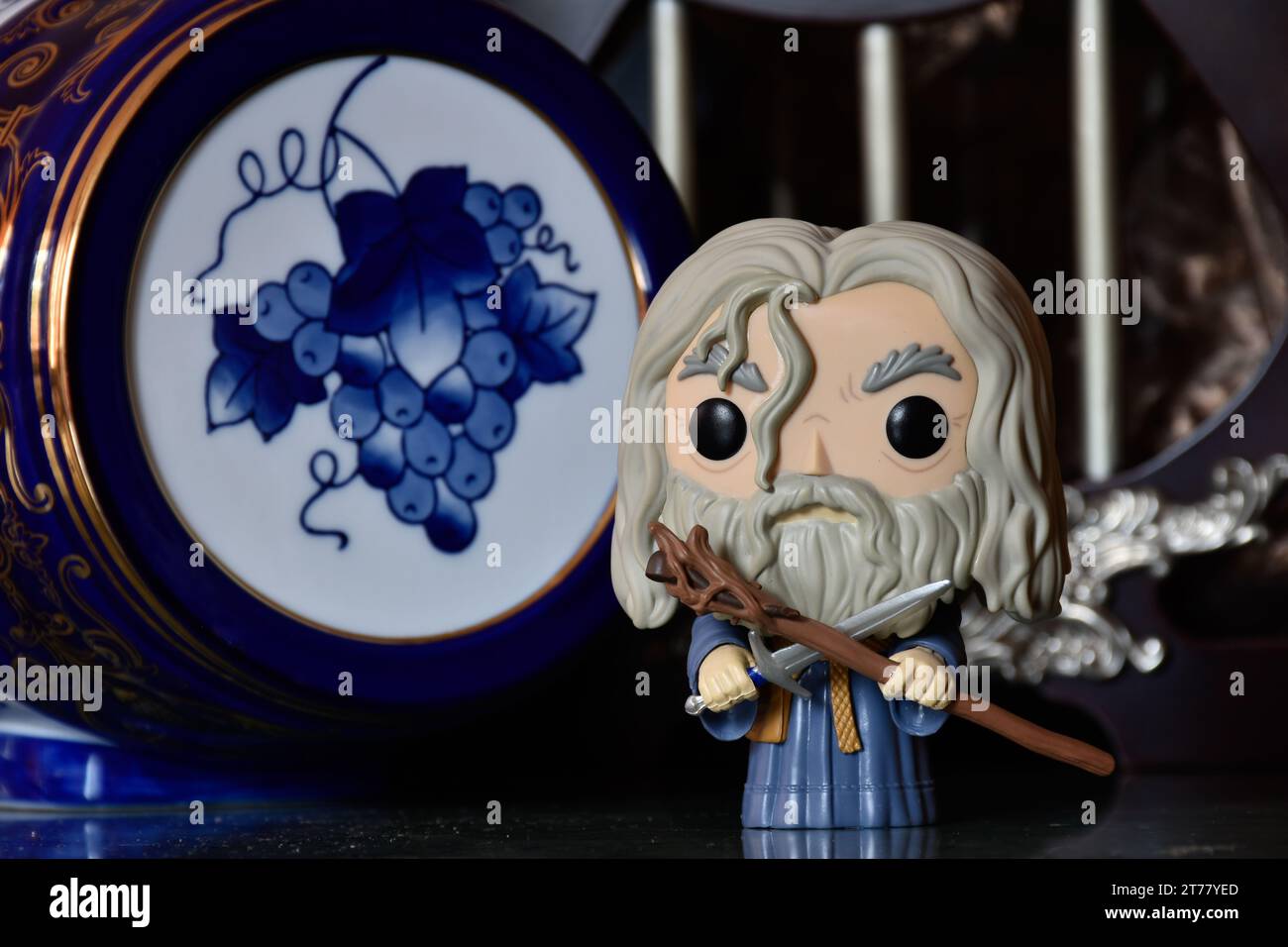 Funko Pop action figure of wizard Gandalf the Grey from fantasy movie The Lord of the Rings. Dark ancient palace with columns, porcelain blue keg. Stock Photo