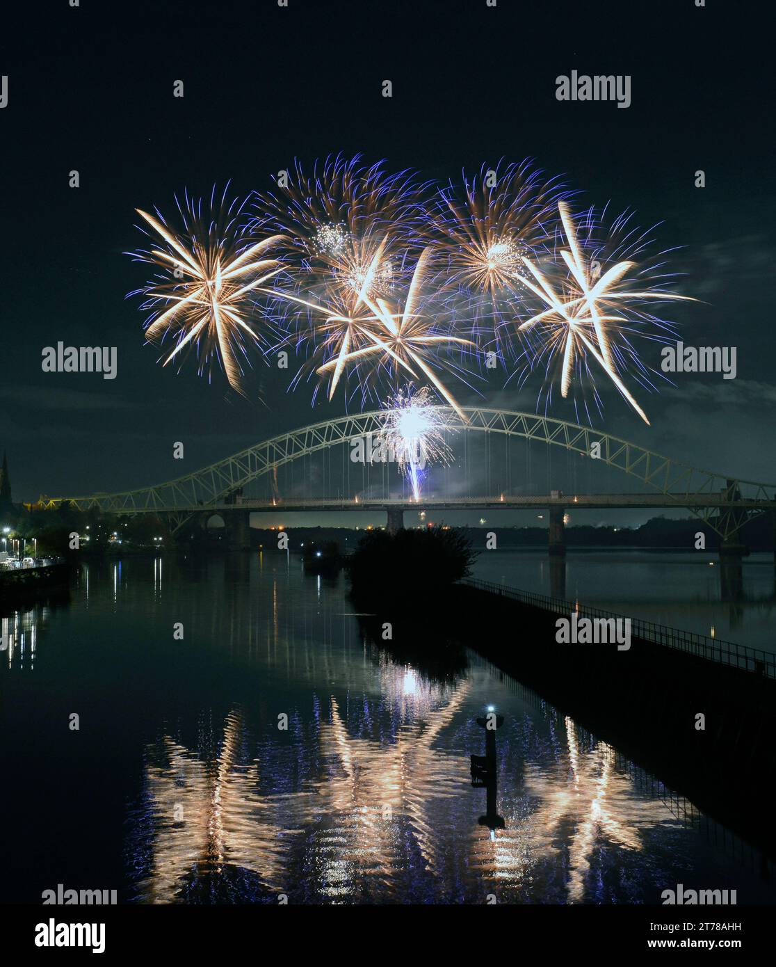Reflections in the Manchester Ship Canal at Old Quay, Runcorn, of the firework display off the Silver Jubilee Bridge, linking Widnes and Runcorn Stock Photo