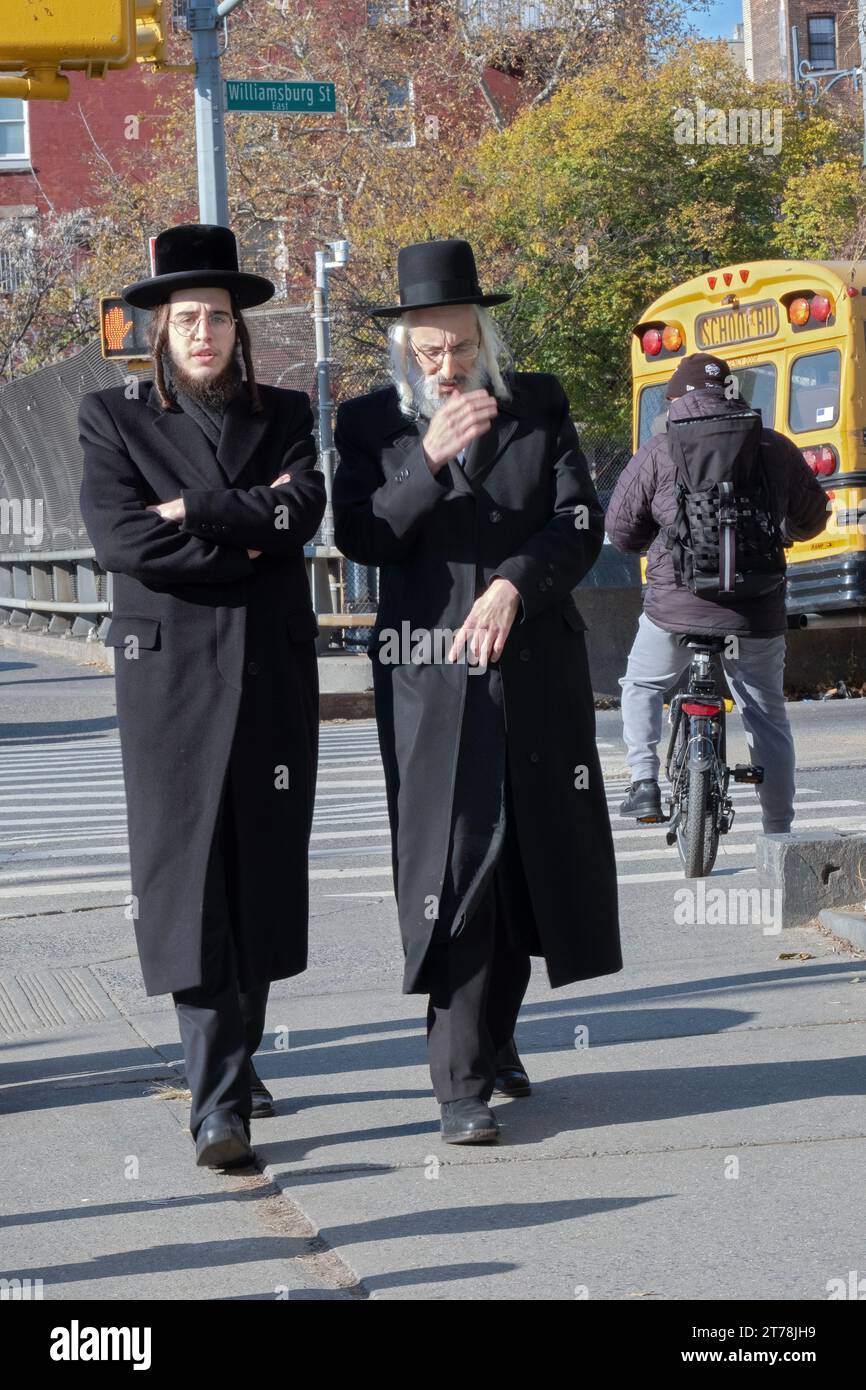 2 orthodox Jewish men, possibly family, walk on Lee Avenue in Brooklyn on a chilly autumn Sunday. Stock Photo