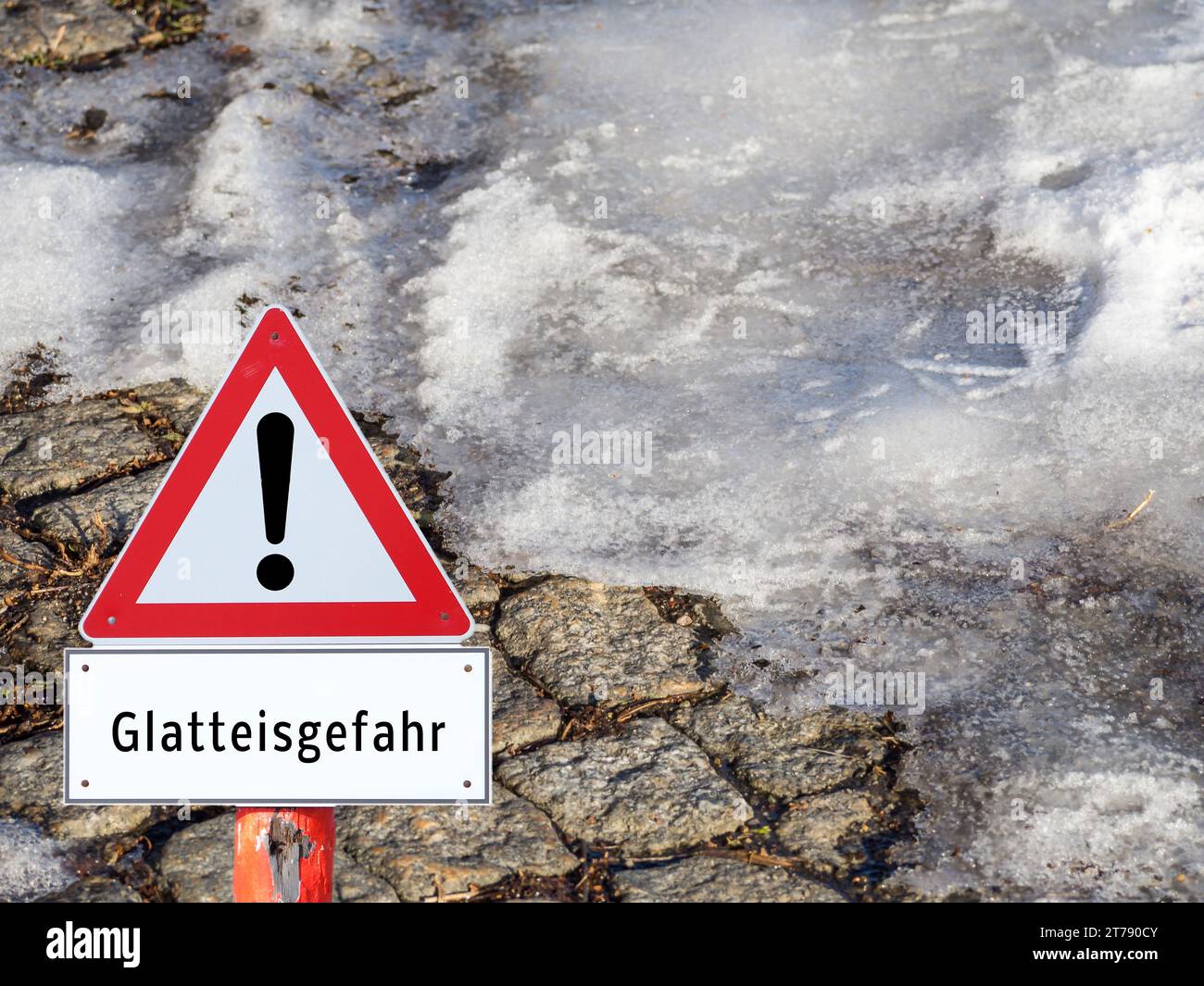 Warning sign: danger of black ice on the footpath in winter in German Stock Photo