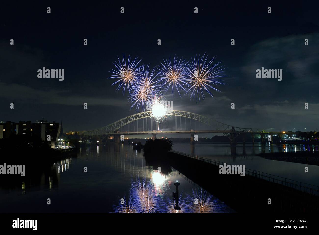 Reflections in the Manchester Ship Canal at Old Quay, Runcorn, of the firework display off the Silver Jubilee Bridge, linking Widnes and Runcorn Stock Photo