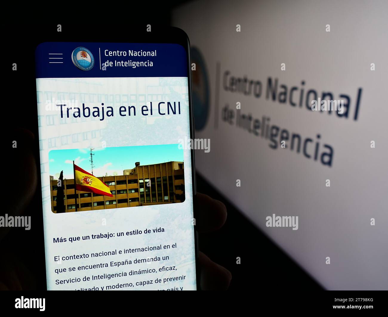 Person holding cellphone with web page of intelligency agency Centro Nacional de Inteligencia (CNI) with logo. Focus on center of phone display. Stock Photo