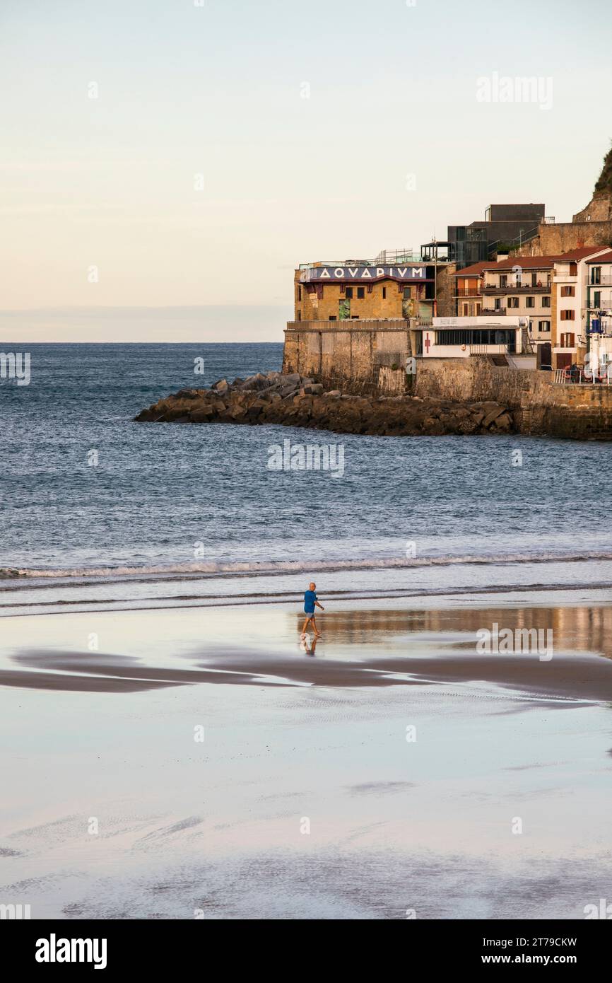 Man walking along the Bahía de La Concha in San Sebastian at low tide in the morning. Stock Photo
