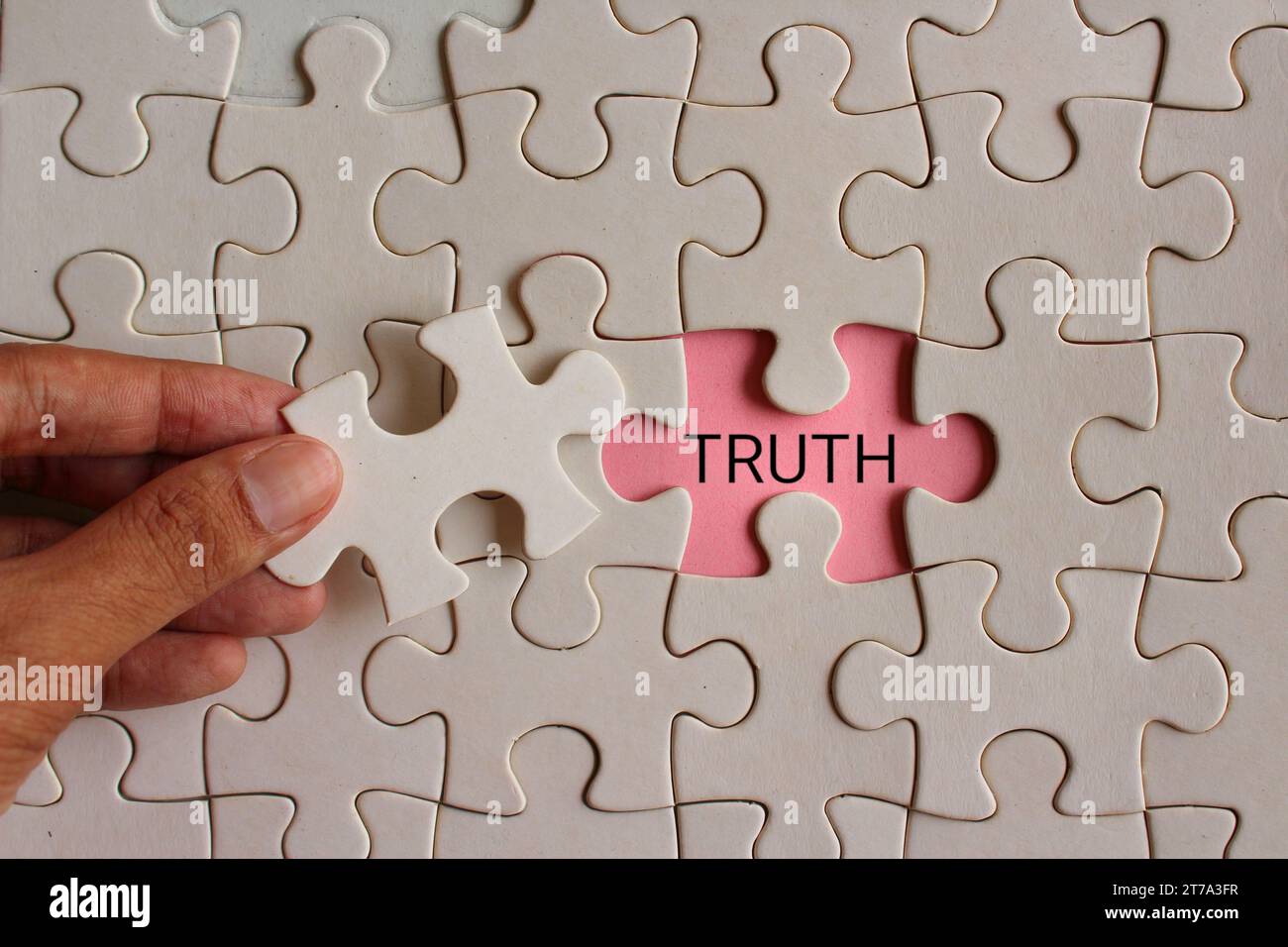 Closeup image of hand pickup puzzle and reveal the word TRUTH Stock