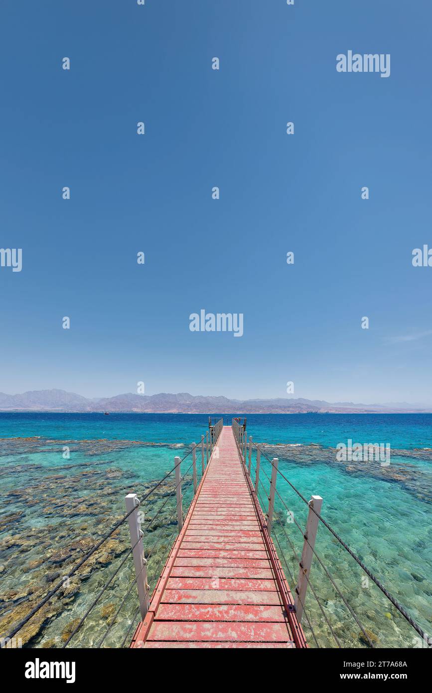 Aquamarine water and underwater corals along empty beach on popular resort of Eilat on Red Sea in Israel. Stock Photo