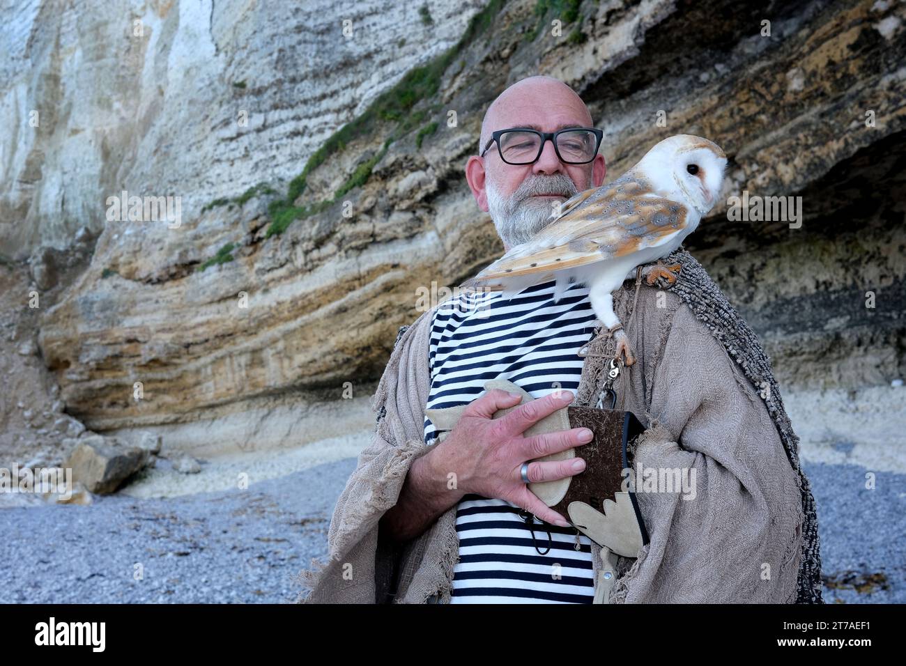 German bird of prey breeder with Barn Owl for photoshoot on the Etretat coastline the 'pointe de la Courtine' on the 'plage d'Antifer' beach near Till Stock Photo