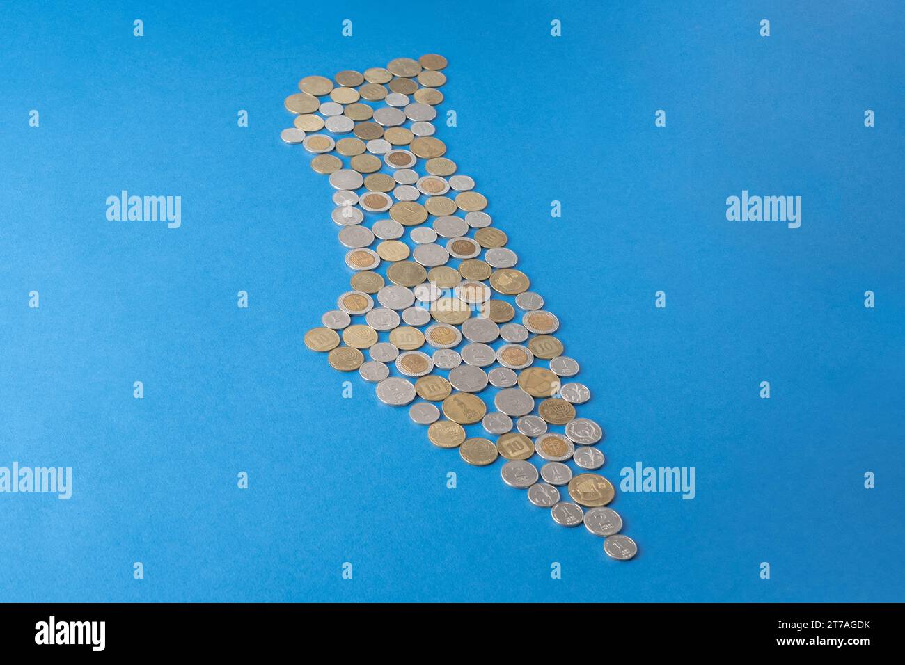 Israel's new shekel coins arranged to form the shape of the map of country Israel on a blue