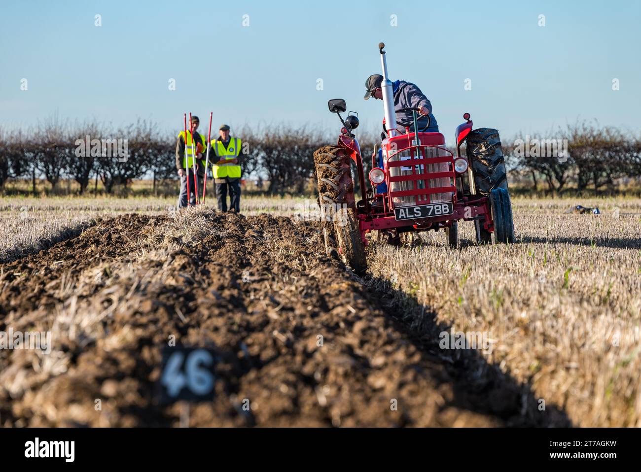 Vintage tractor ploughing furrows with judges watching in ploughing match, East Lothian, Scotland, UK Stock Photo