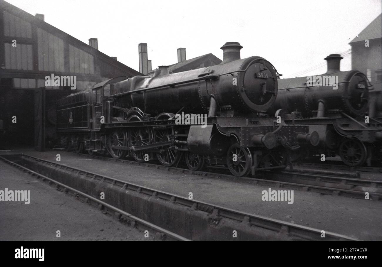 1950s, historical, two steam locomotives of the era outside a railway shed, England, UK. Number 5959 was a 4-6-0 GWR locomotive 'Mawley Hall' which entered service in 1936. It was withdrawn in 1962. Beside it, a GWR locomotive 9306, a Churchward 2-6-0 which entered service in 1932. Stock Photo