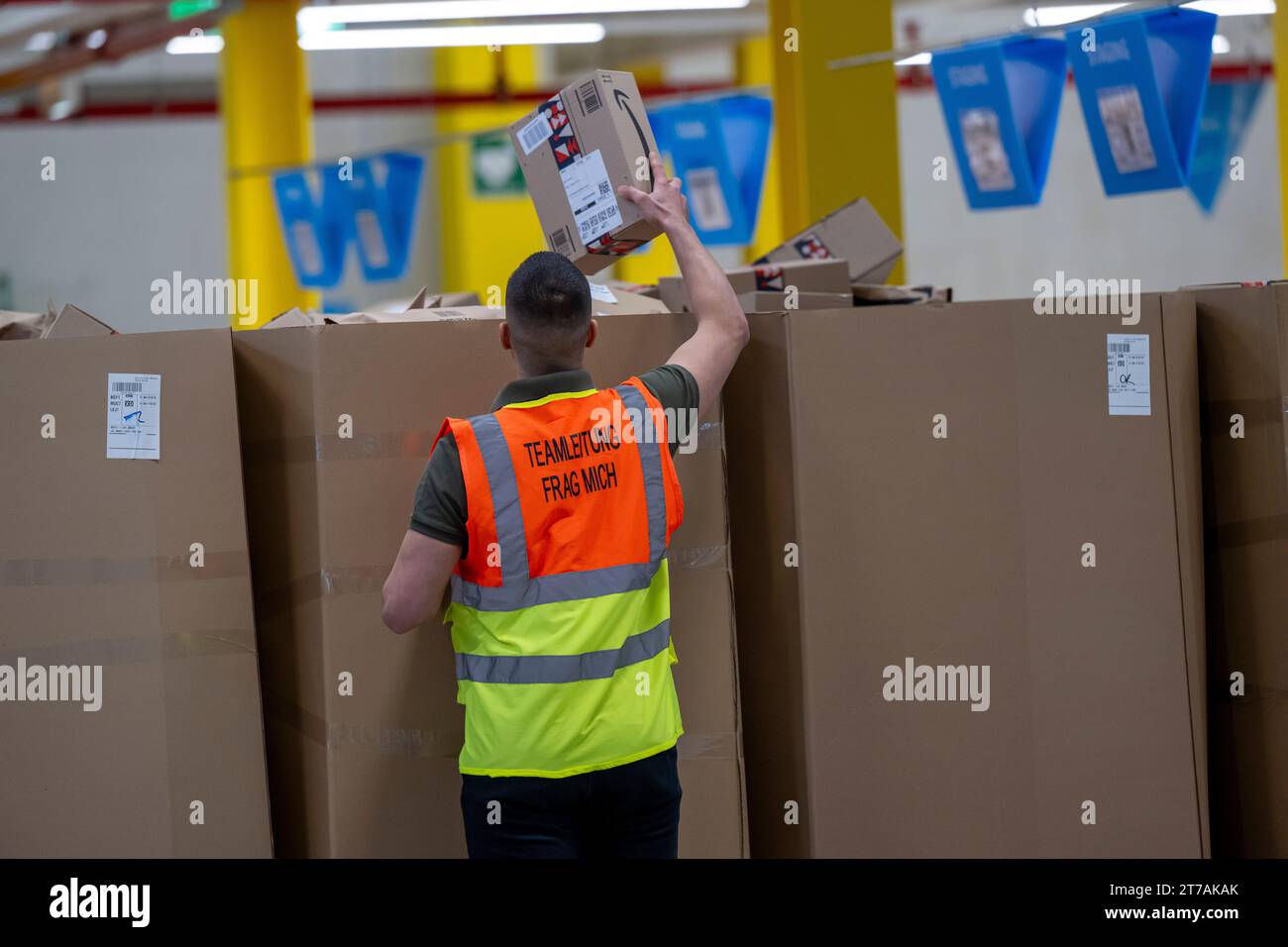 Erding, Germany. 14th Nov, 2023. An Amazon employee explains the processes in the facility at