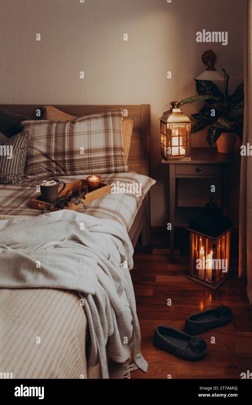 cozy scandinavian bedroom interior in natural tones, blanket candles houseplants Stock Photo