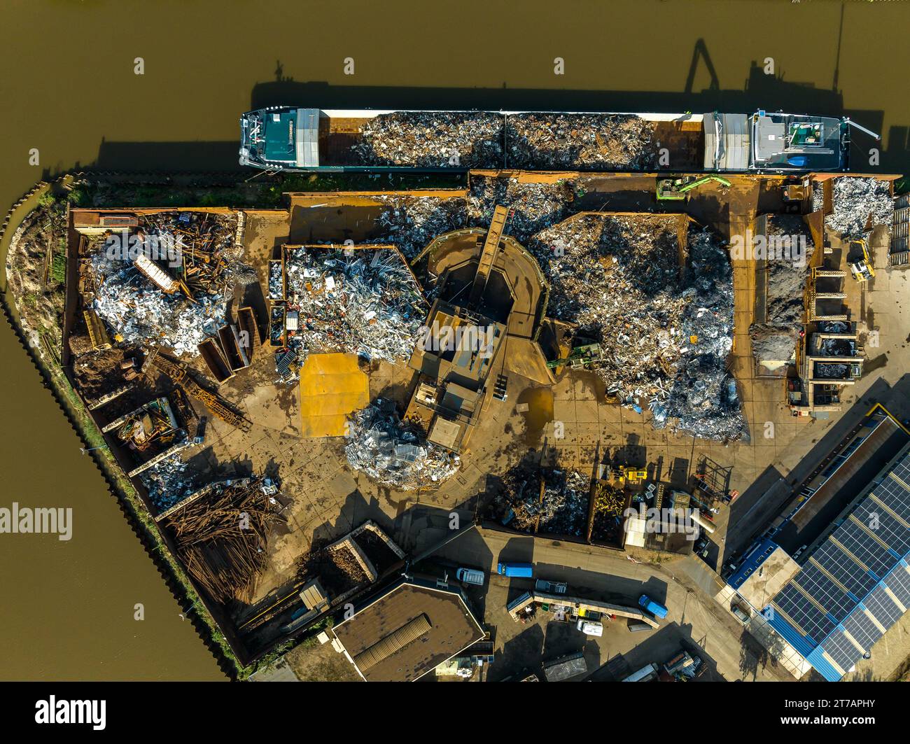 aerial view of a professional scrapyard along a canal Stock Photo