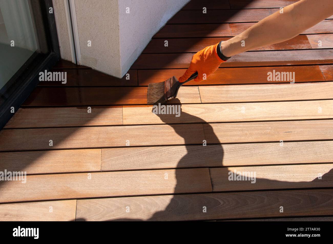 Deck sealing, worker hand applying a wood stain Stock Photo Alamy