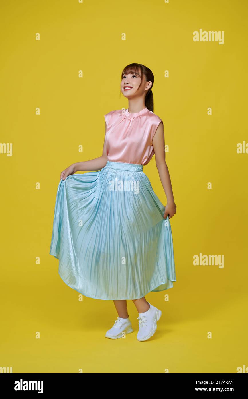 young girl happy positive smile go walk look empty space isolated over yellow background Stock Photo