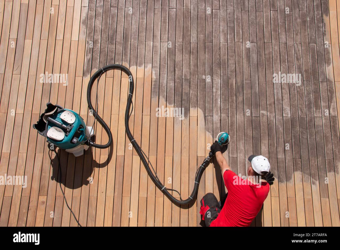 Wood deck repair top view, gray ipe decking boards maintenance, man