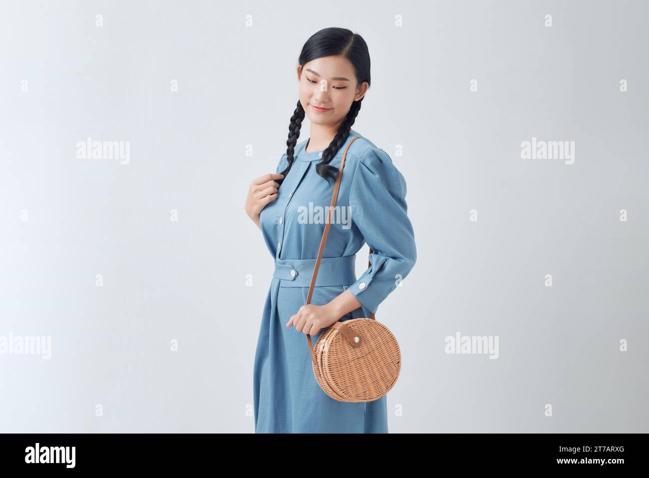 Beautiful fashionable asian woman wearing stylish denim dress, with a round shoulder bag Stock Photo