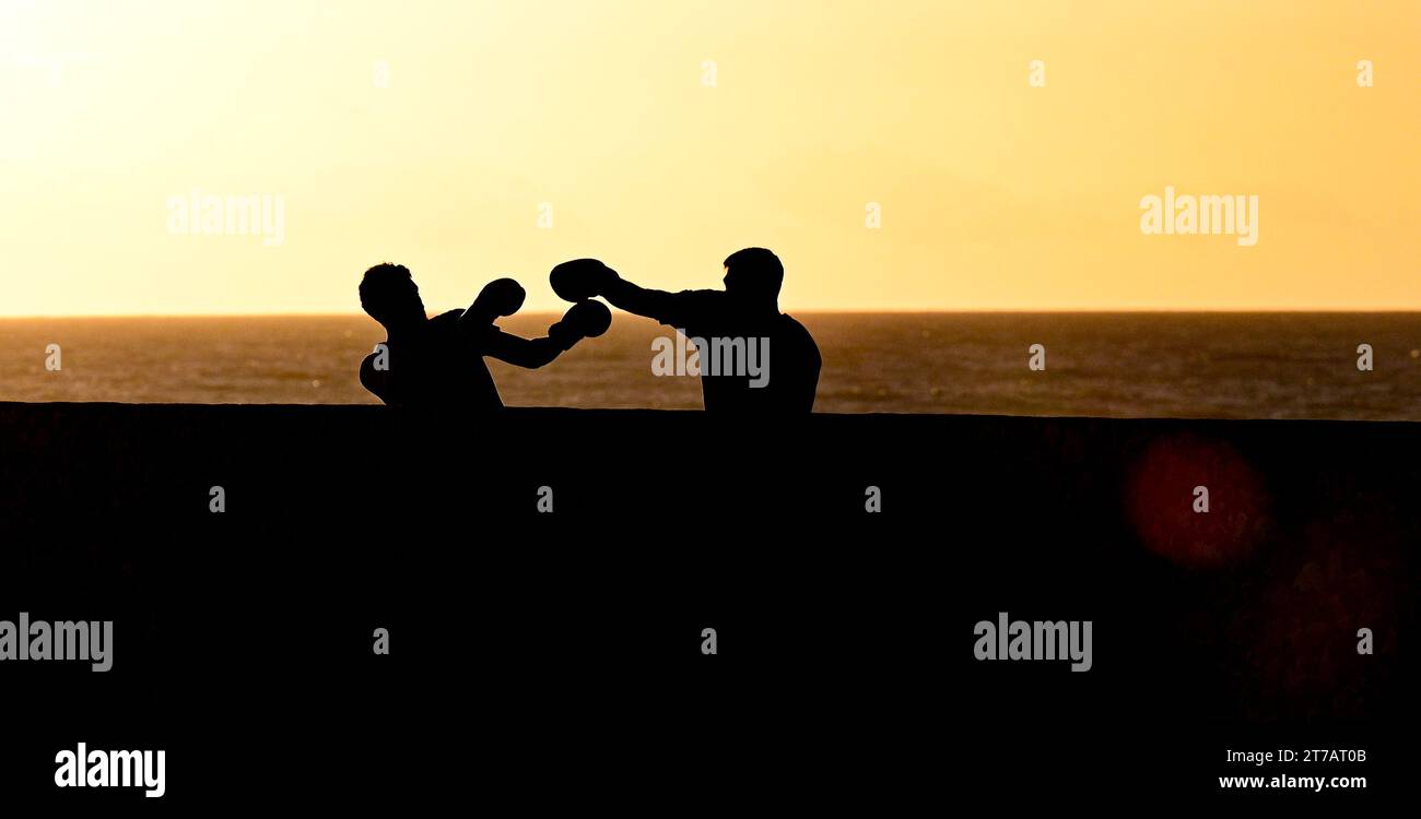 Brighton UK 14th November 2023 - Boxers sparring on Brighton seafront as the sun goes down behind after a day of sunshine and showers along the South Coast : Credit Simon Dack / Alamy Live News Stock Photo
