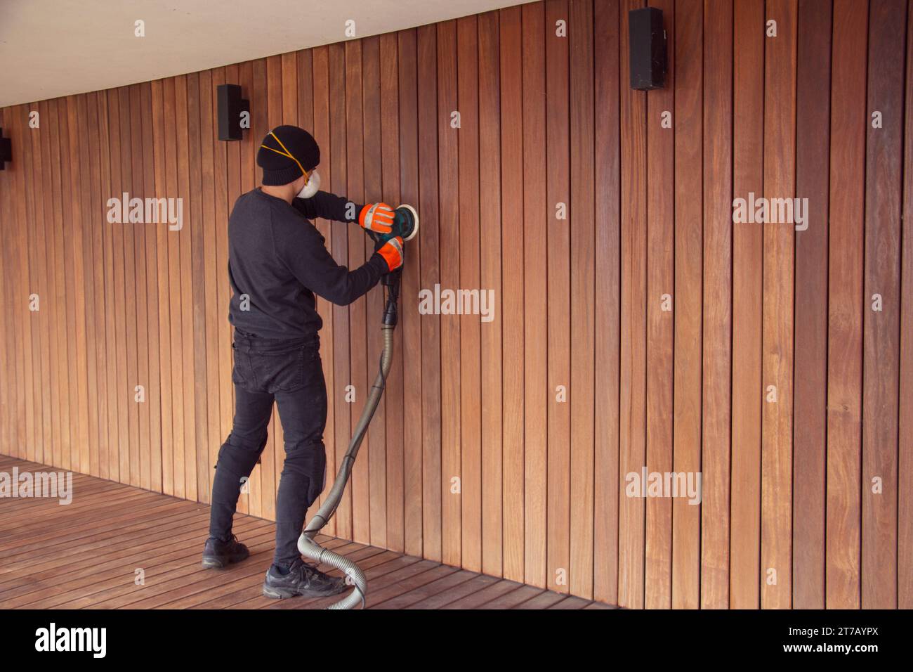 Wood cladding and deck sanding, Man sanding wooden cladding with
