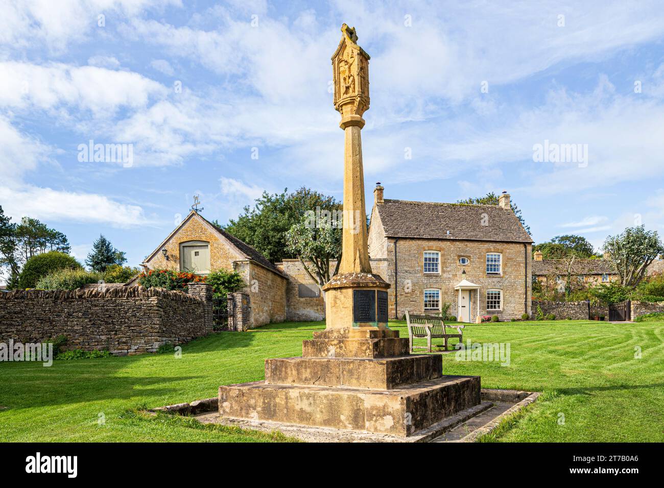 The war memorial and Civic Trust House on the green in the Cotswold village of Guiting Power, Gloucestershire, England UK Stock Photo