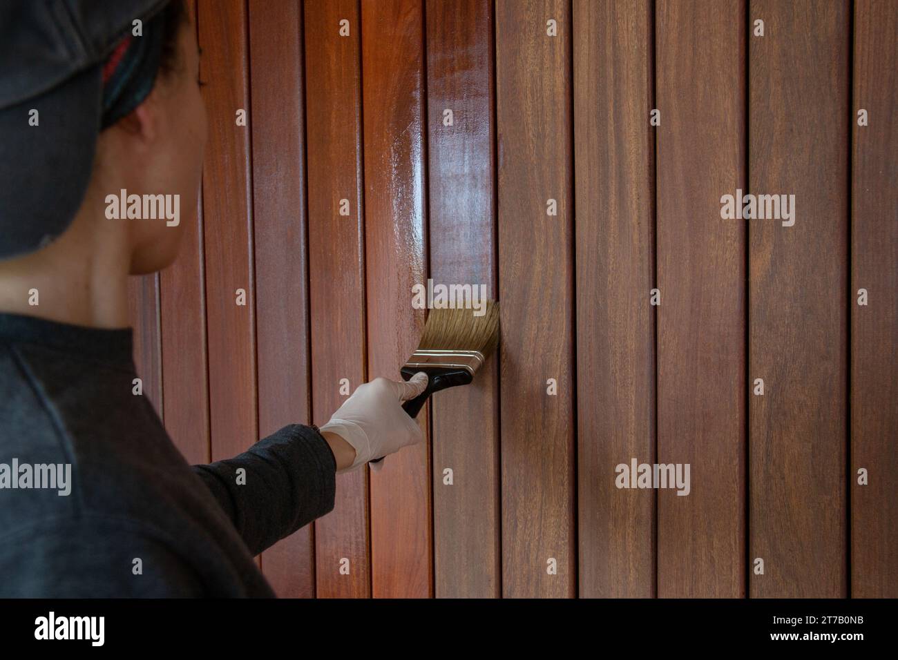 Woodworker is treating wood with oil, applies refreshing protection on