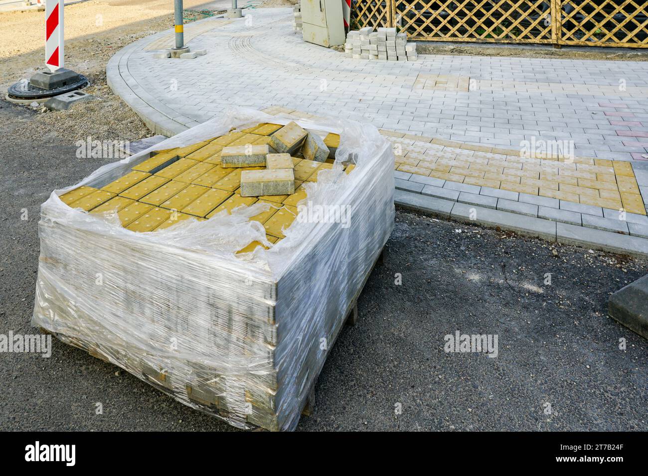 Street reconstruction view, pallet with yellow tactile paving stones for blind in foreground Stock Photo