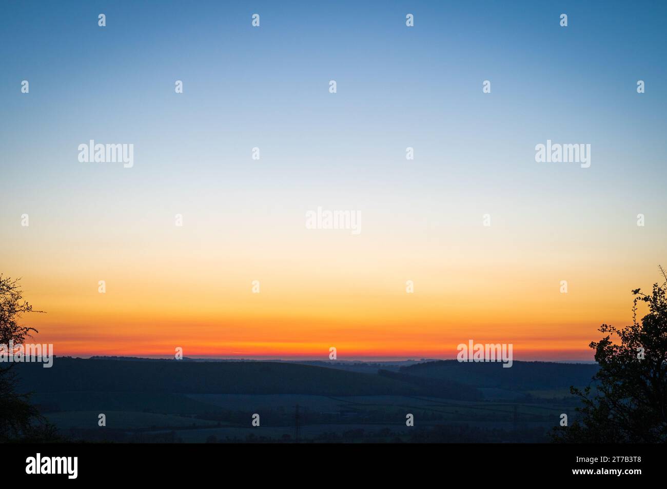 A colourful sunset across the South Downs National Park as seen from Butser Hill, Queen Elizabeth Country Park, Hampshire, England, UK Stock Photo