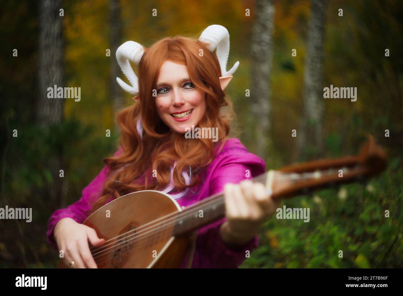A whimsical moment featuring a female Tiefling from Dungeons & Dragons, laughing mischievously with a sly glance to the side. Posed playfully with a l Stock Photo