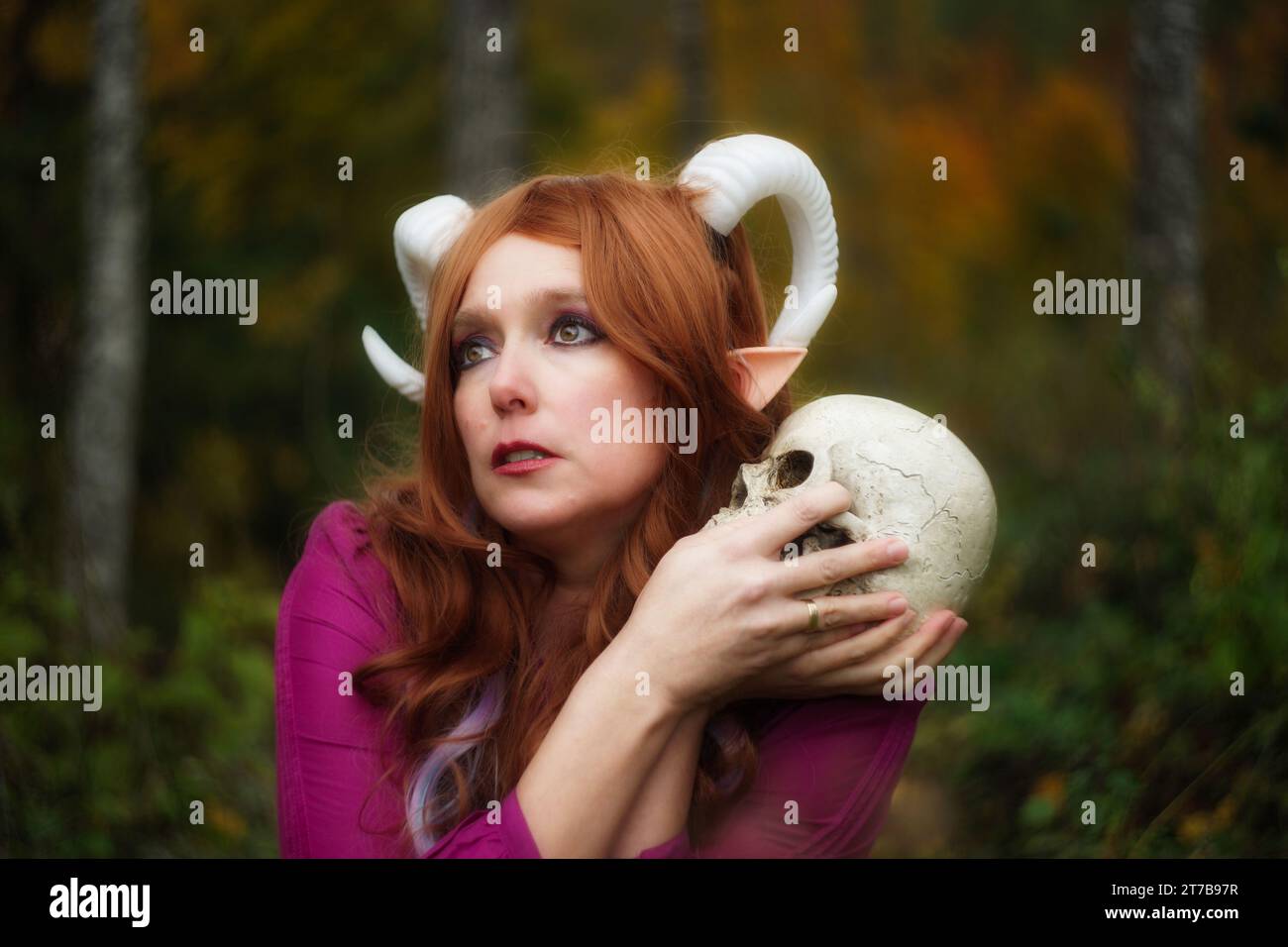 A captivating scene featuring a female Tiefling from Dungeons & Dragons, holding a skull with a yearning and concerned gaze into the distance. Express Stock Photo