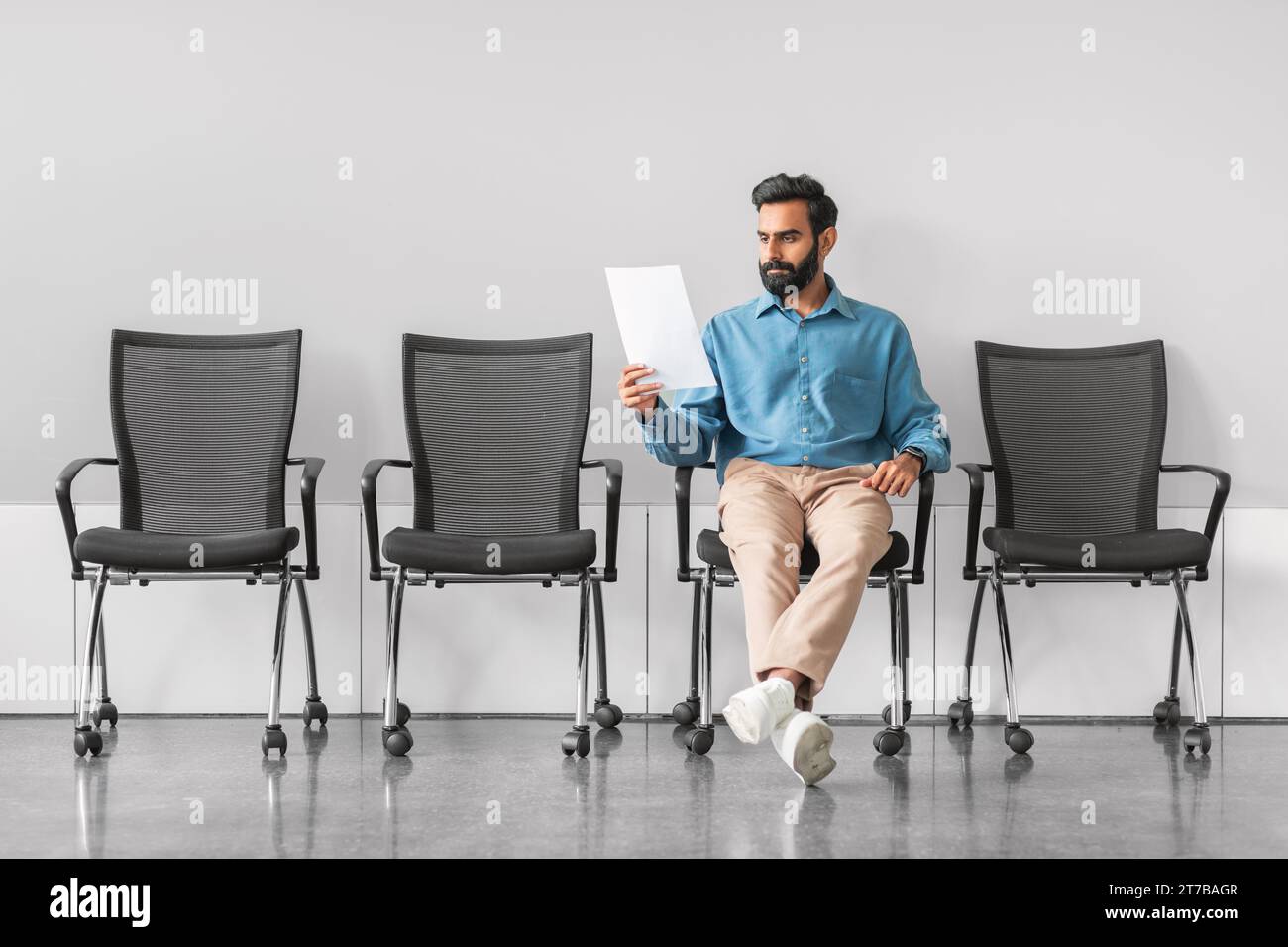 Indian man analyzing document in job interview waiting room Stock Photo