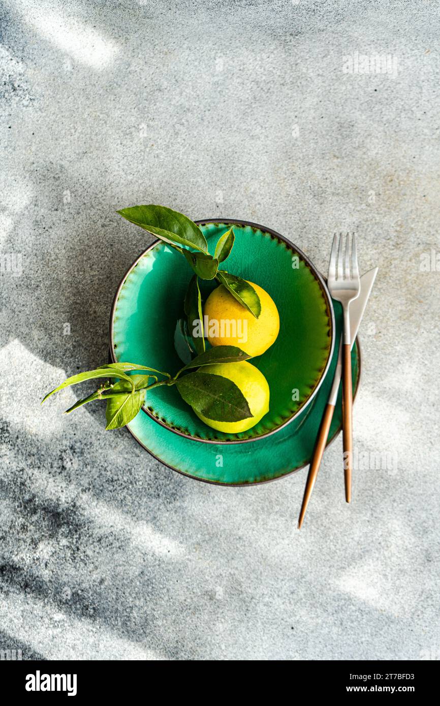 Overhead view of two freshly picked Ripe lemons decorating a place setting Stock Photo