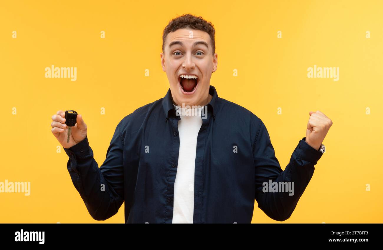 Happy excited young man showing key from new car Stock Photo - Alamy