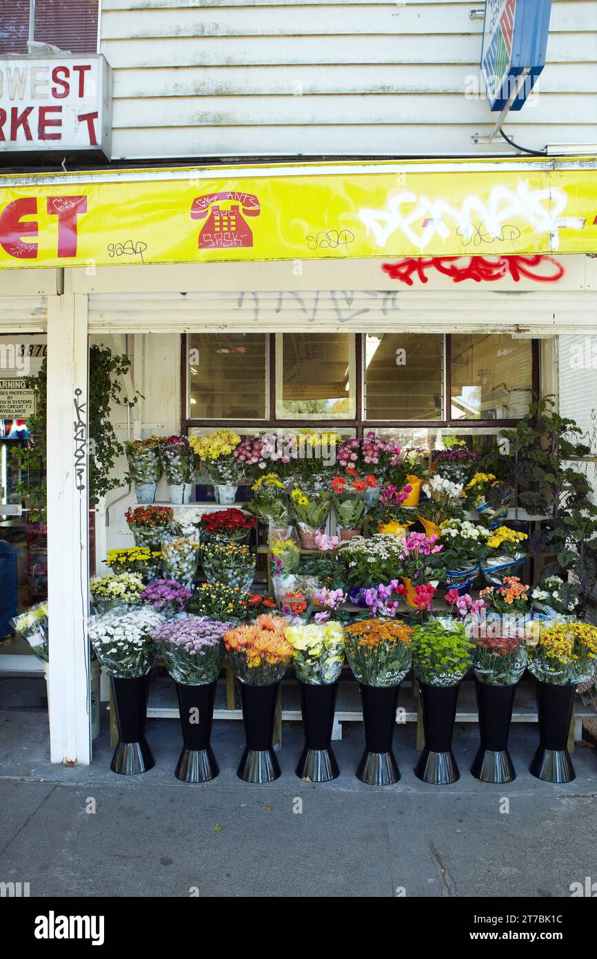 Flower bouquet display on sidewalk in front of general store. Vancouver