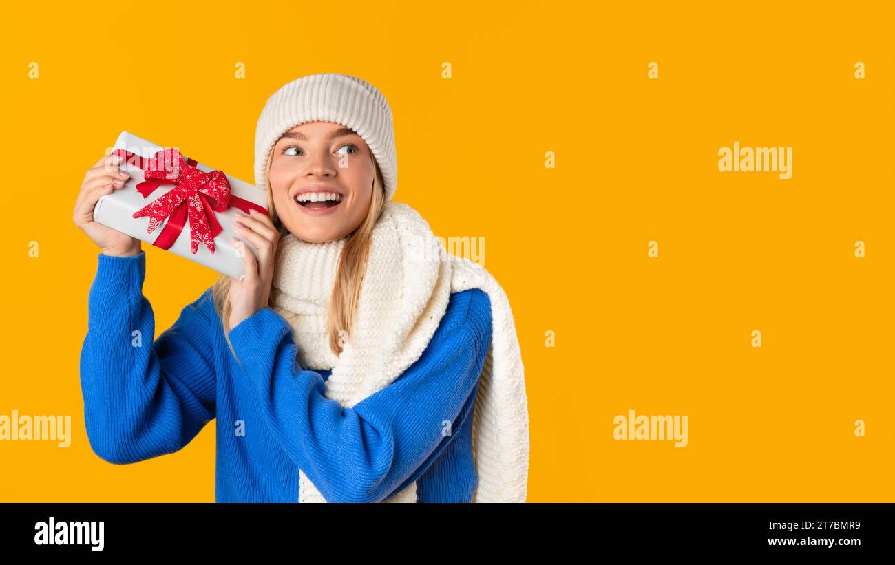 Happy woman holding a gift box with joy Stock Photo