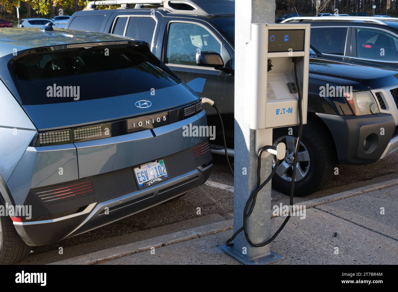 Hyundai Ioniq 5 electric car and Eaton public charger in a parking lot on the campus of Michigan State University, East Lansing Michigan Stock Photo