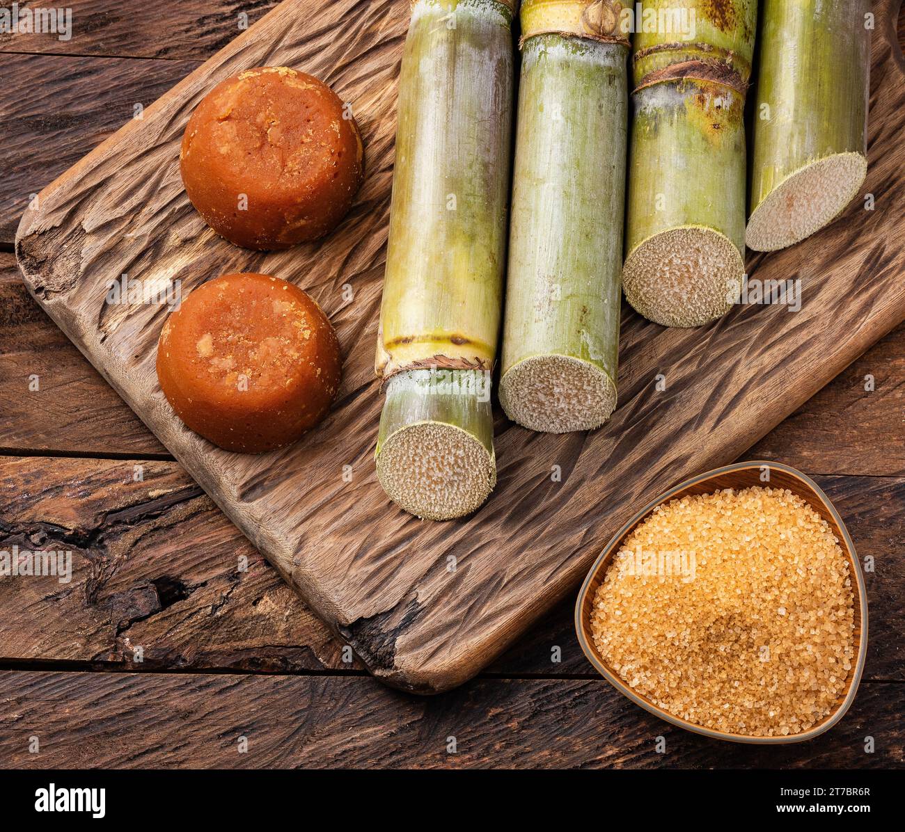 Saccharum officinarum - Panela and brown sugar with sugar cane stalks Stock Photo