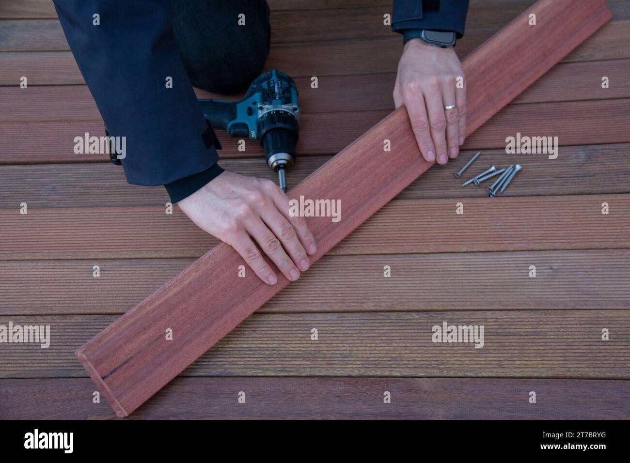 Deck installation carpenter hands holding ipe board, terrace decking