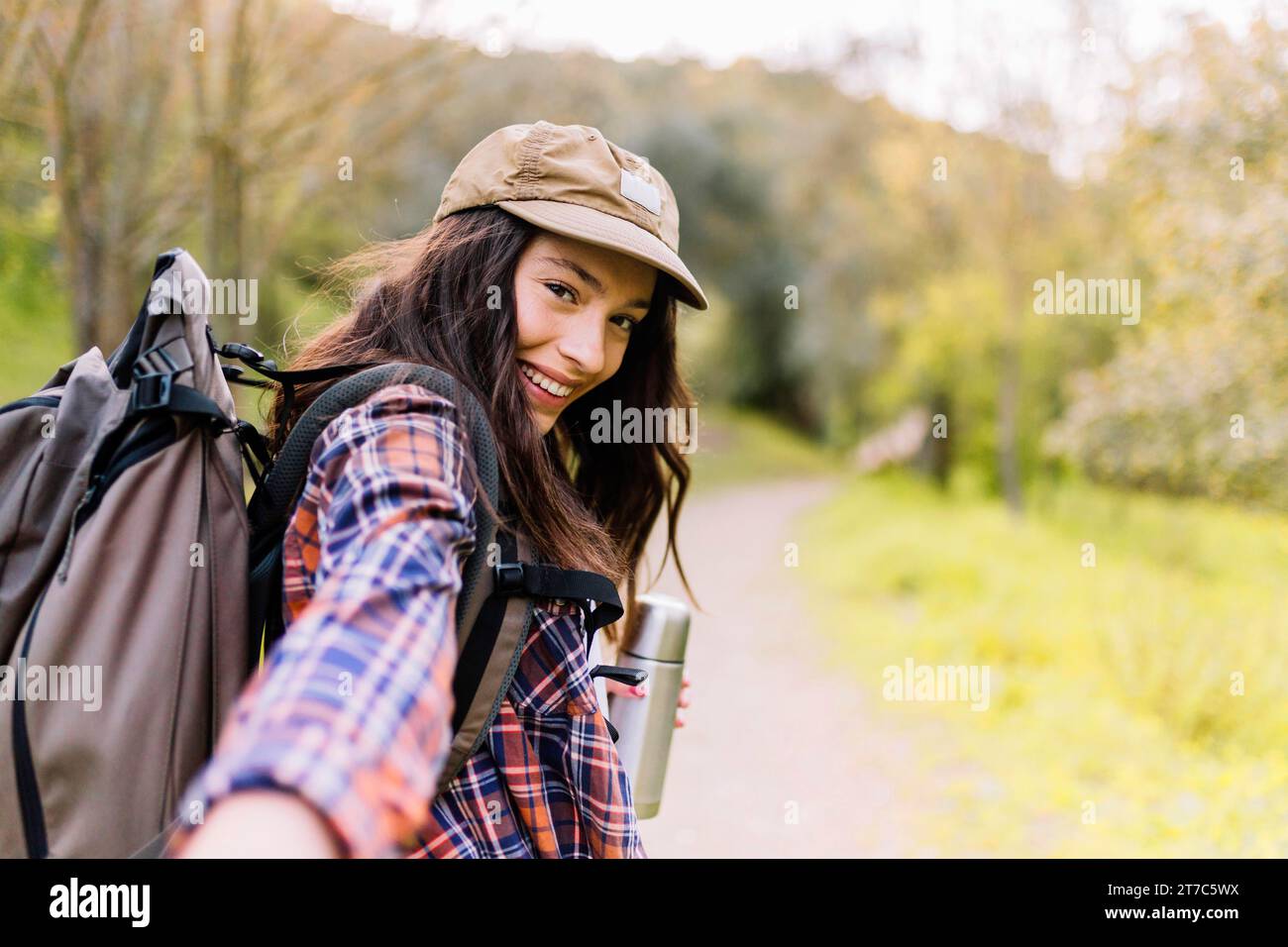 Charming woman with thermos offering tow walk with her Stock Photo