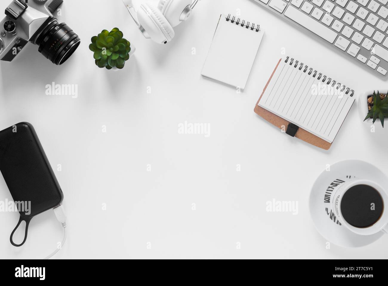 Camera power bank cactus plant diary tea cup keyboard white desk Stock Photo
